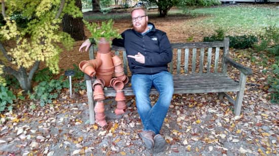 Tim, sitting on a bench with a scarecrow.